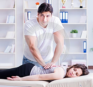 Young doctor chiropractor massaging female patient woman