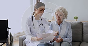 Young doctor consult disabled old grandma show medical test results