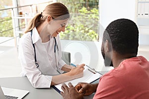 Young doctor consulting African-American patient