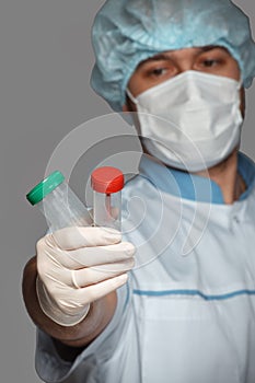 Young doctor with container for analysis