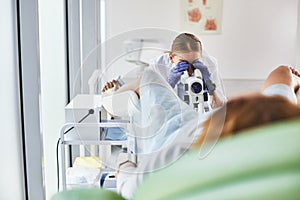 Young doctor doing gynecological examination of female patient photo