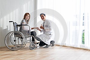 Young doctor encouraged the female patient on broken arm and wheelchair patient