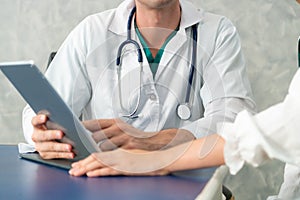 Young doctor examining patient in hospital office.