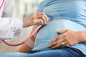 Young doctor examining pregnant woman in clinic