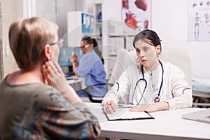 Young doctor examining senior patient