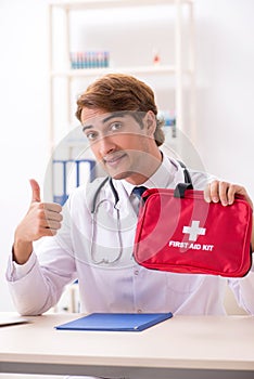 The young doctor with first aid kit in hospital