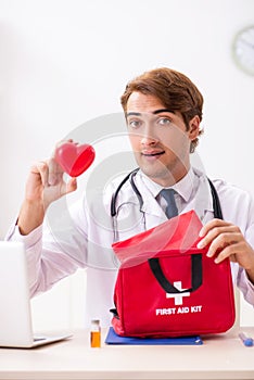 The young doctor with first aid kit in hospital