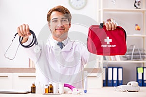 The young doctor with first aid kit in hospital