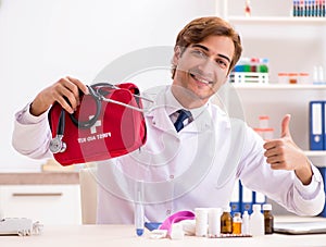 Young doctor with first aid kit in hospital