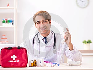Young doctor with first aid kit in hospital