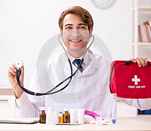 Young doctor with first aid kit in hospital