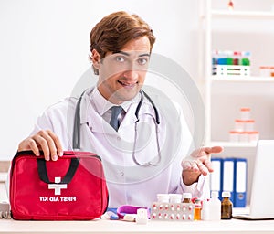 Young doctor with first aid kit in hospital