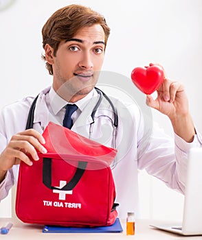 Young doctor with first aid kit in hospital