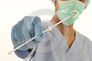 Young doctor holding an IUD birth control copper coil device in hand