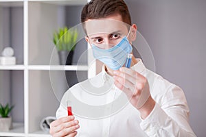 Young doctor holding test tubes with virus tests.