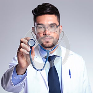 Young doctor holding up stethoscope