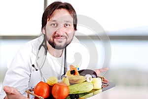 Young doctor in hospital with plenty of fruits