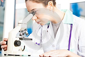 Young doctor looking into a microscope