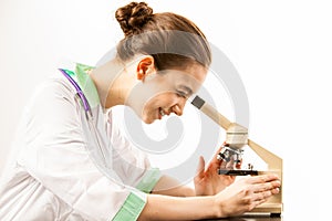 Young doctor looking into a microscope