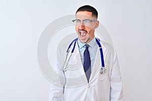 Young doctor man wearing stethoscope over isolated background angry and mad screaming frustrated and furious, shouting with anger