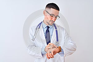 Young doctor man wearing stethoscope over isolated background Checking the time on wrist watch, relaxed and confident