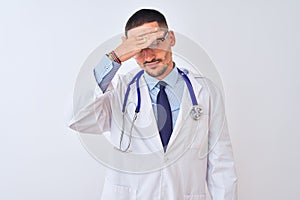 Young doctor man wearing stethoscope over isolated background covering eyes with hand, looking serious and sad