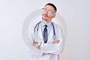 Young doctor man wearing stethoscope over isolated background looking to the side with arms crossed convinced and confident