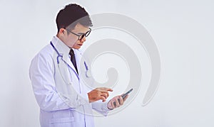 Young doctor man wearing a white coat using a smartphone