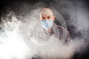 Young doctor in a mask in smoke