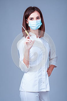 Young doctor in medical mask with a syringe