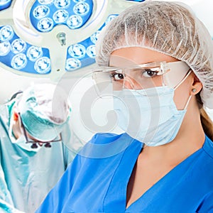 Young doctor in operation room with surgeon on background