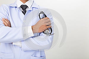 Young doctor, physician holding his stethoscope in hand with arm