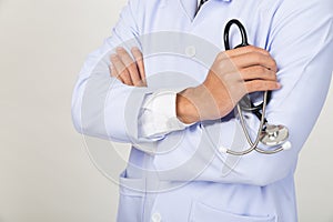 Young doctor, physician holding his stethoscope in hand with arm