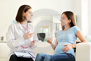Young doctor with pregnant woman in clinic