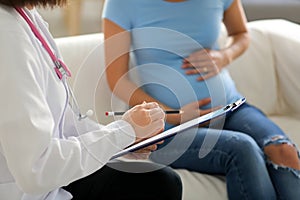 Young doctor with pregnant woman in clinic