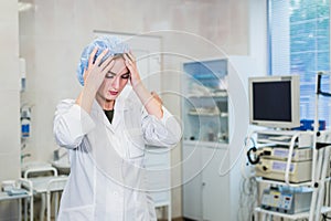 Young doctor during preparation for operation. Assistant of surgeon wearing medical cap in operation room at the