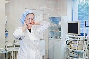 Young doctor during preparation for operation. Assistant of surgeon wearing medical cap in operation room at the