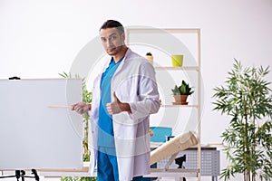 Young male doctor in presentation concept