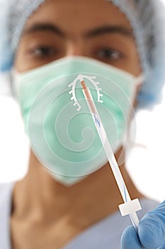 Young doctor ready to use an IUD birth control copper coil device in hand