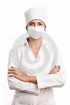 Young doctor standing with arms folded over white