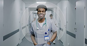 Young doctor stands in middle of hospital corridor