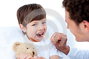 Young doctor taking little boy's temperature