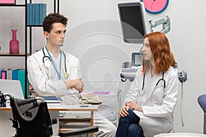 A young doctor talks to a redheaded intern about his next patient. GP. Doctor& x27;s office