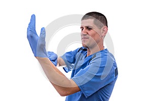 Young doctor in uniform getting ready to work putting on gloves isolated on a white background