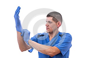 Young doctor in uniform getting ready to work putting on gloves isolated on a white background