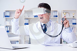 Young doctor with vr virtual reality headset working in the offi