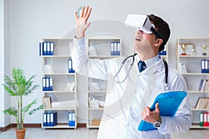 Young doctor with vr virtual reality headset working in the offi