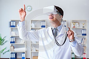 Young doctor with vr virtual reality headset working in the offi