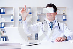 Young doctor with vr virtual reality headset working in the offi