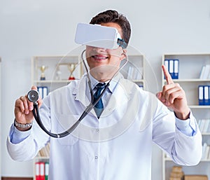 Young doctor with vr virtual reality headset working in the offi